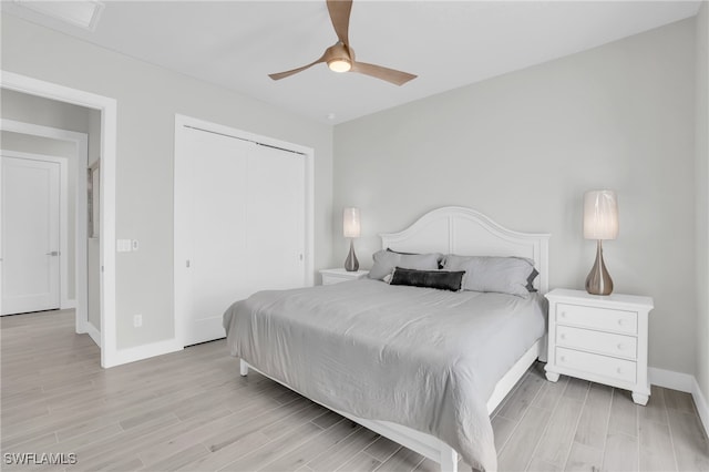 bedroom with a closet, light hardwood / wood-style floors, and ceiling fan