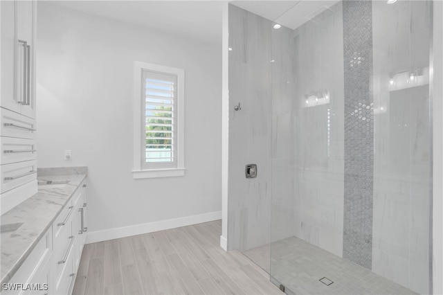 bathroom with vanity, wood-type flooring, and tiled shower