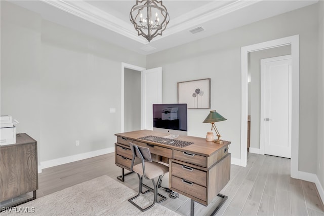 home office featuring crown molding, a raised ceiling, light hardwood / wood-style flooring, and a chandelier