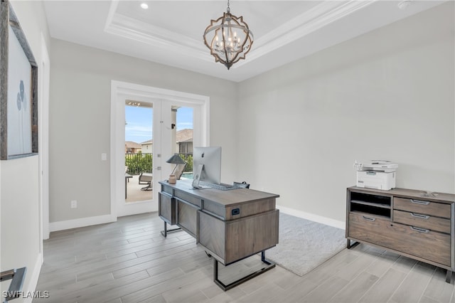 office area with light hardwood / wood-style flooring, a notable chandelier, ornamental molding, and a tray ceiling