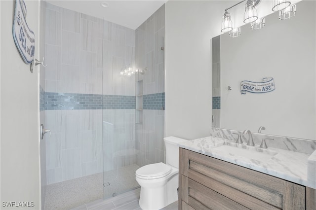 bathroom featuring vanity, toilet, and tiled shower