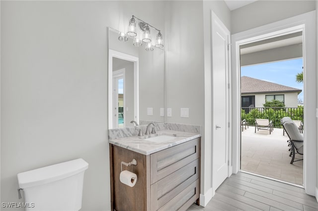 bathroom with vanity, hardwood / wood-style flooring, and toilet