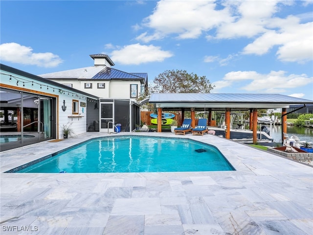 view of swimming pool with a patio area and a water view