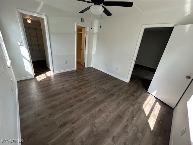 empty room with ceiling fan and dark hardwood / wood-style flooring