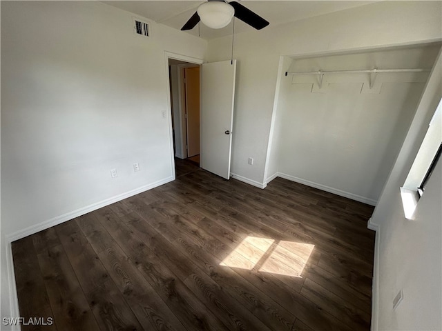 unfurnished bedroom featuring dark wood-type flooring, a closet, and ceiling fan