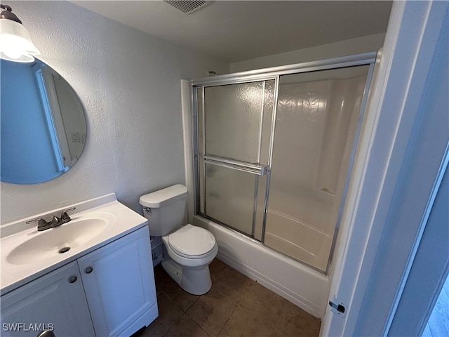 full bathroom featuring vanity, bath / shower combo with glass door, toilet, and tile patterned floors