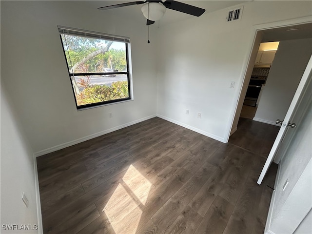 spare room with dark hardwood / wood-style floors and ceiling fan