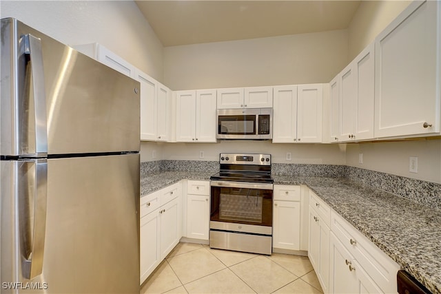 kitchen with white cabinetry, stainless steel appliances, and light stone counters