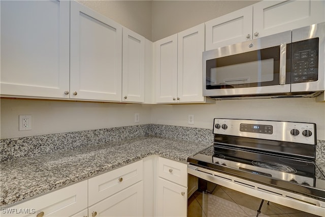 kitchen featuring white cabinets, appliances with stainless steel finishes, and tile patterned floors