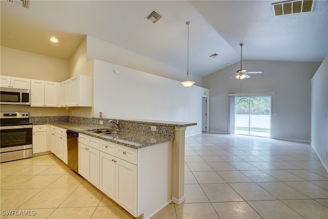 kitchen featuring stainless steel appliances, light tile patterned flooring, kitchen peninsula, stone countertops, and white cabinets