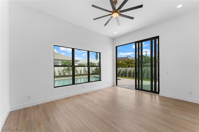 empty room with light wood-type flooring, a wealth of natural light, and ceiling fan