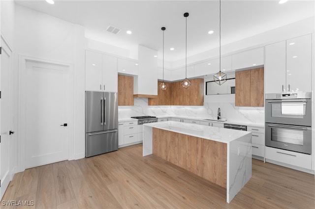 kitchen featuring decorative light fixtures, white cabinetry, and appliances with stainless steel finishes