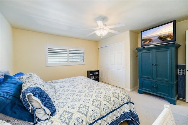 bedroom featuring ceiling fan, light carpet, and a closet