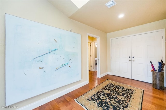 entrance foyer featuring wood-type flooring and lofted ceiling