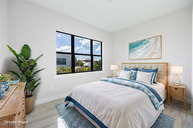 bedroom with baseboards and wood finished floors