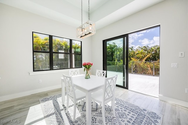 dining room featuring light wood-type flooring and an inviting chandelier