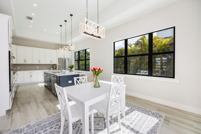 dining room with recessed lighting, baseboards, visible vents, and light wood finished floors