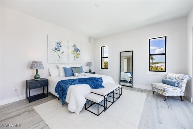 bedroom featuring light wood finished floors, baseboards, and visible vents