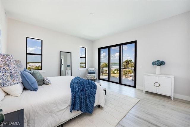 bedroom featuring light wood finished floors, access to outside, and baseboards