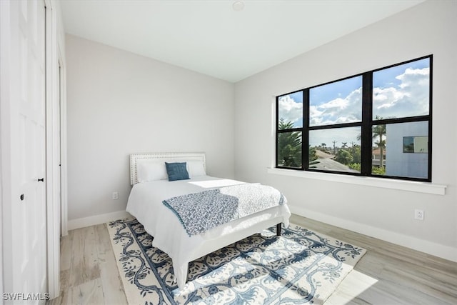 bedroom with light wood-style flooring and baseboards