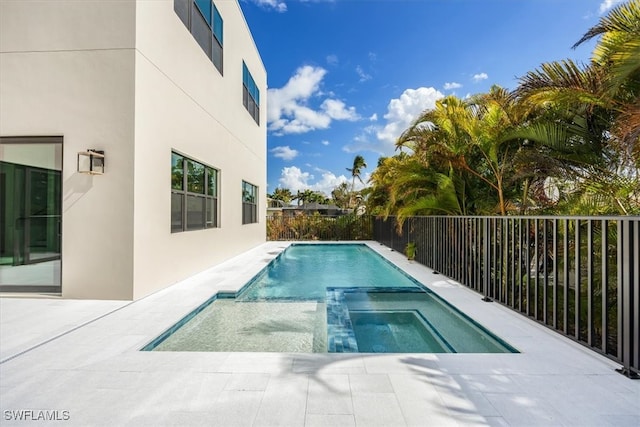 view of pool with a pool with connected hot tub, fence, and a patio