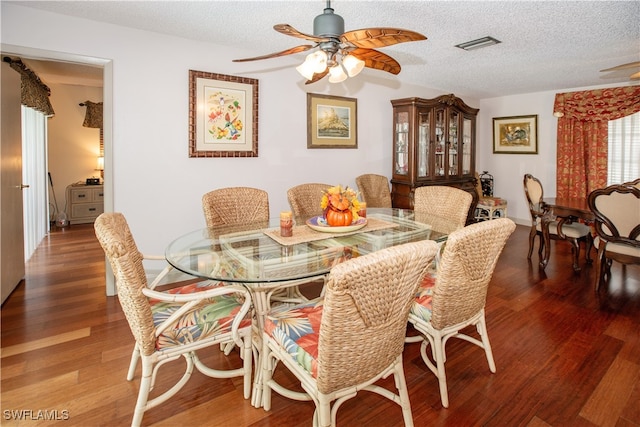 dining space with a textured ceiling, wood-type flooring, and ceiling fan