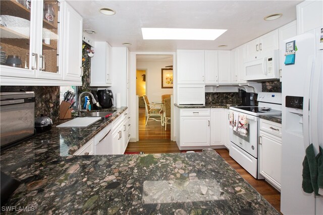 kitchen featuring white appliances, sink, white cabinets, dark wood-type flooring, and decorative backsplash