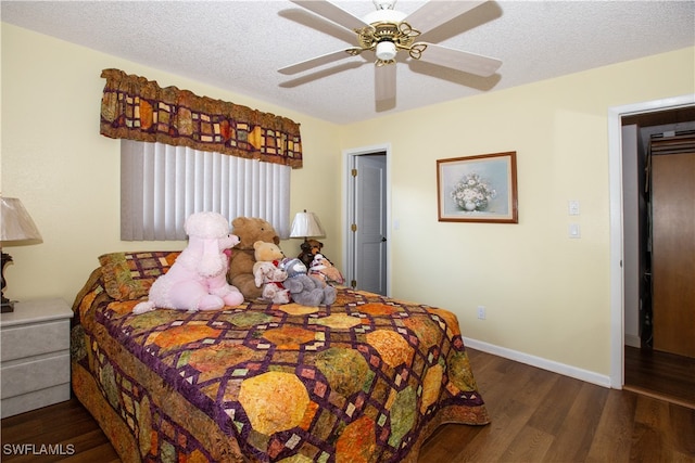 bedroom with a textured ceiling, dark hardwood / wood-style floors, and ceiling fan