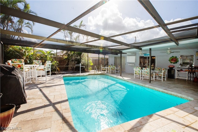 view of swimming pool with ceiling fan, a patio area, and a lanai