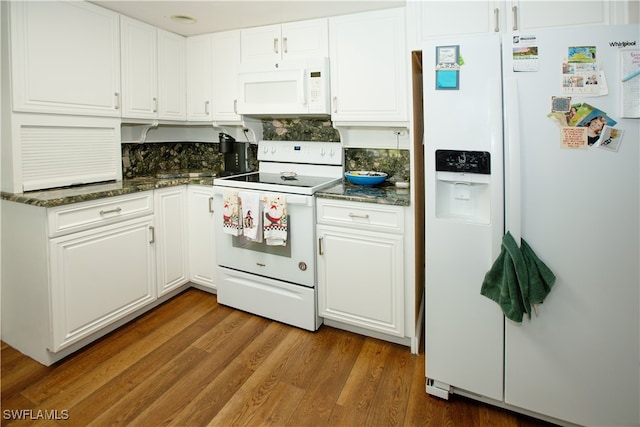 kitchen with white cabinetry, dark stone counters, white appliances, and dark hardwood / wood-style flooring