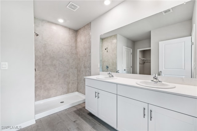 bathroom featuring tiled shower, hardwood / wood-style floors, and vanity