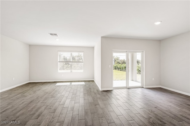 empty room with wood-type flooring and a wealth of natural light