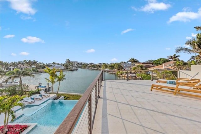 view of pool with a water view and a patio