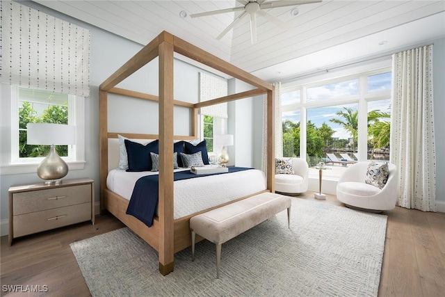 bedroom with multiple windows and hardwood / wood-style flooring