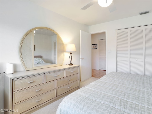 bedroom featuring a closet, ceiling fan, and light colored carpet