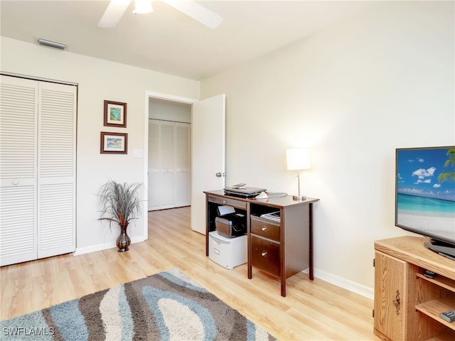 office with light hardwood / wood-style flooring and ceiling fan