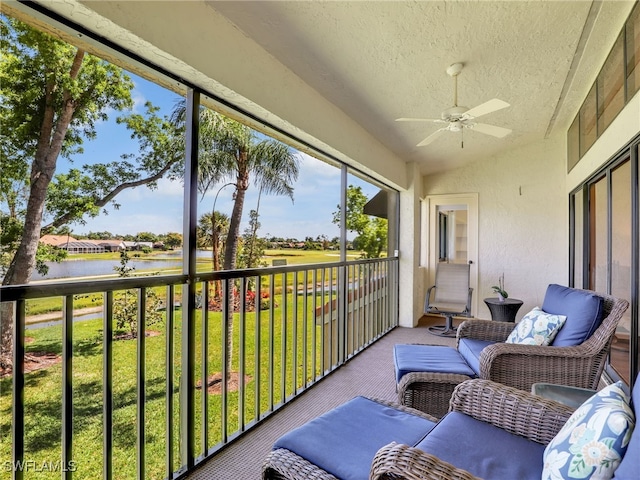 sunroom / solarium featuring a water view and ceiling fan