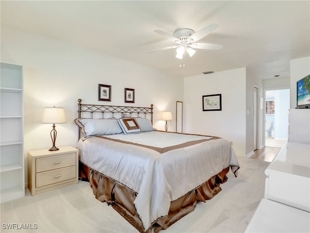 bedroom featuring light colored carpet, connected bathroom, and ceiling fan