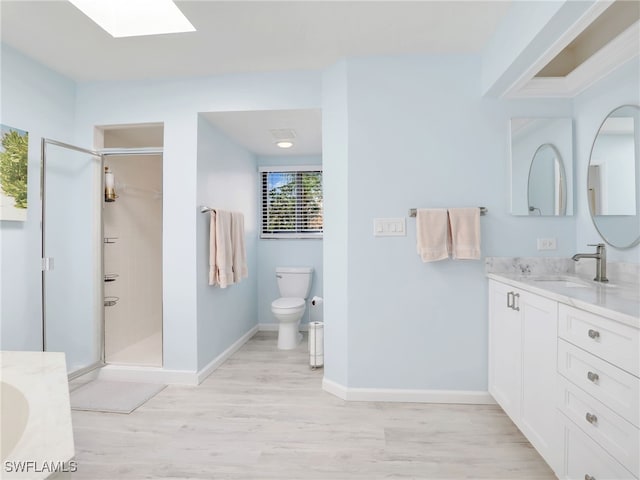 bathroom with toilet, hardwood / wood-style flooring, walk in shower, and vanity