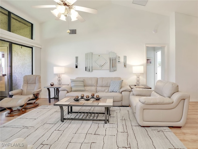 living room with light hardwood / wood-style flooring, high vaulted ceiling, and ceiling fan