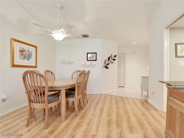 dining area with light hardwood / wood-style flooring and ceiling fan