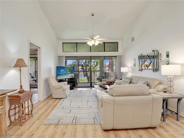 living room with light hardwood / wood-style floors, high vaulted ceiling, and ceiling fan