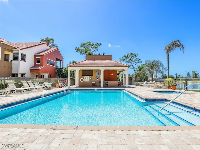 view of pool with a patio and a hot tub