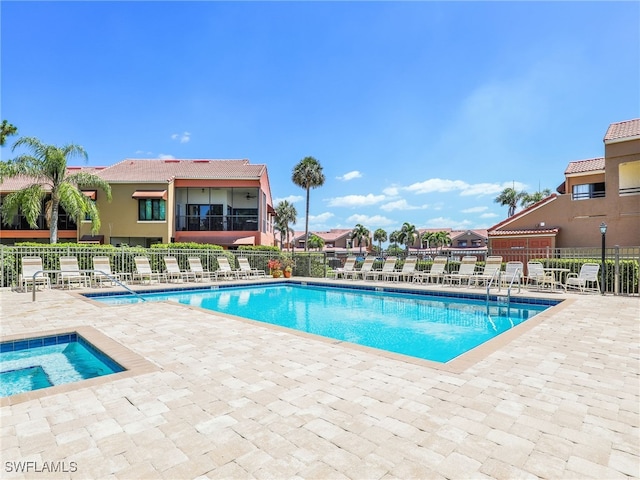 view of pool with a patio area and a hot tub