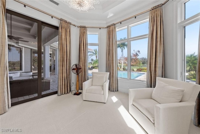 living area featuring an inviting chandelier, carpet flooring, visible vents, and crown molding