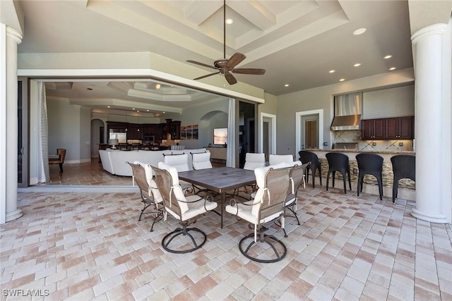 dining room featuring ornate columns, arched walkways, a raised ceiling, and recessed lighting