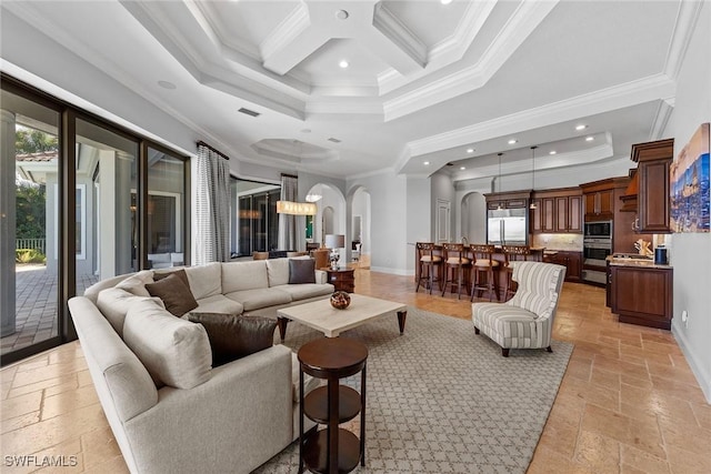 living area with stone tile floors, arched walkways, baseboards, a towering ceiling, and crown molding