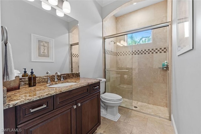 full bathroom with a stall shower, vanity, and toilet