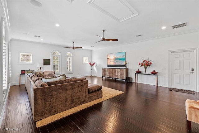 living area with dark wood-style floors, recessed lighting, visible vents, and ornamental molding