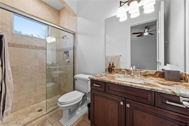 full bathroom featuring a stall shower, vanity, toilet, and a ceiling fan